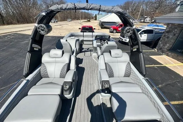 Slide: The Image of 2024 Manitou LX 25 SRS pontoon boat with luxurious seating and modern design. - 16