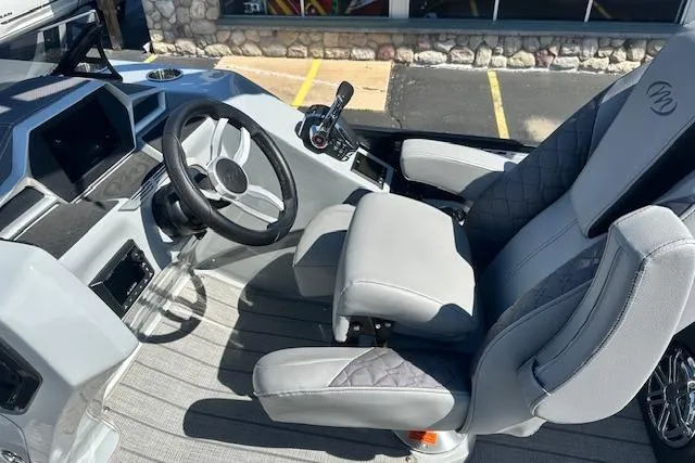 Slide: The Image of 2024 Manitou LX 25 SRS boat interior with modern steering and seating. - 22