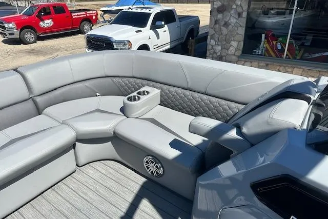 Slide: The Image of 2024 Manitou LX 25 SRS boat interior with gray seating and cup holders. - 29