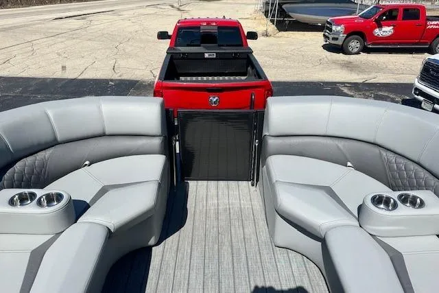 Slide: The Image of 2024 Manitou LX 25 SRS pontoon boat interior with red truck in background. - 31