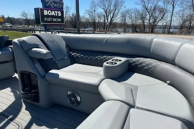 Slide: The Image of 2024 Manitou LX 25 SRS boat interior with luxurious gray seating and cup holders. - 32