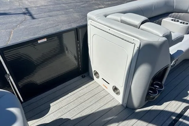 Slide: The Image of 2024 Manitou LX 25 SRS pontoon boat interior with gray seating and cup holders. - 35