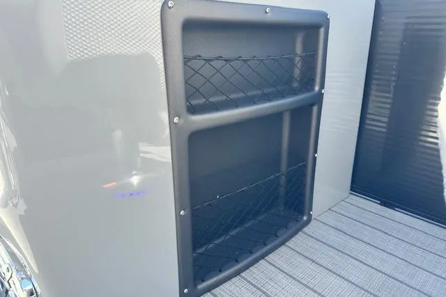 Slide: The Image of 2024 Manitou LX 25 SRS storage compartment with netting on a sleek exterior. - 39