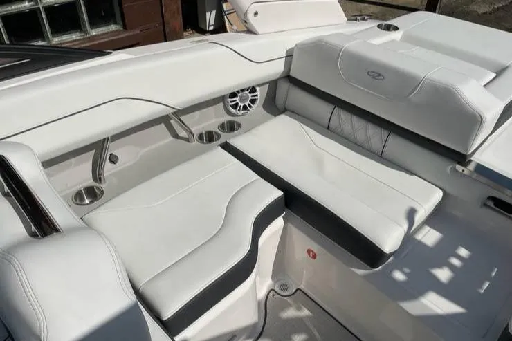 Slide: The Image of 2025 Regal LS2 Surf boat interior with white leather seating and cup holders. - 8