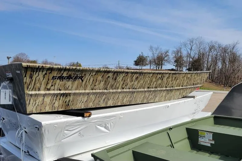 The Image of 2025 Smoker Craft 1648 jon boat with camouflage design, 16-foot length, displayed outdoors. - 1
