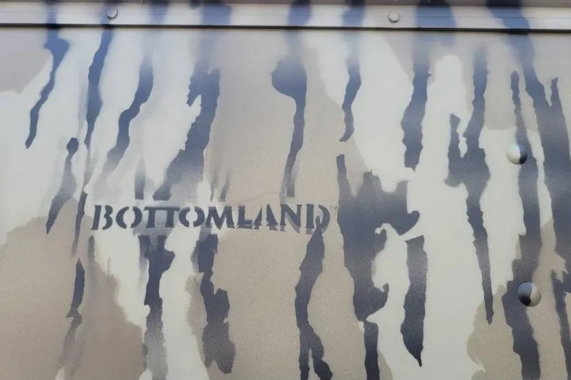Slide: The Image of Camouflage pattern on 2025 Smoker Craft 1648 jon boat with "Bottomland" text. - 6