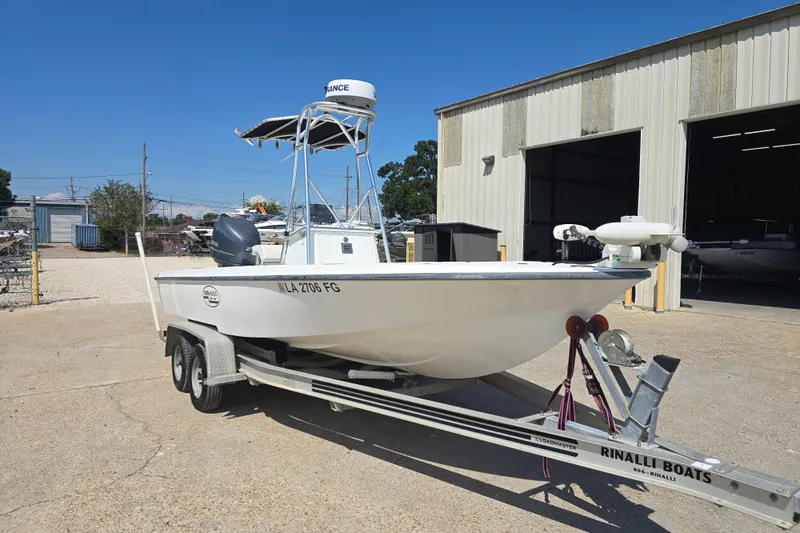 Slide: The Image of 2002 Rinalli 2100 boat on trailer outside a warehouse, sunny day. - 12