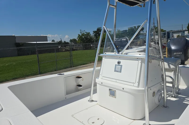 Slide: The Image of 2002 Rinalli 2100 boat interior with console and seating, parked outdoors. - 14