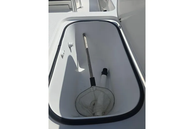Slide: The Image of Open storage compartment on 2002 Rinalli 2100 boat with fishing net inside. - 16