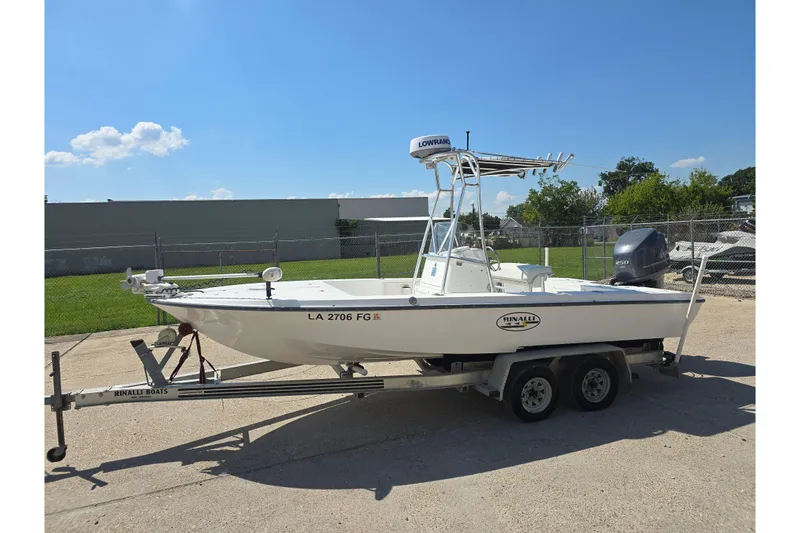 Slide: The Image of 2002 Rinalli 2100 boat on trailer, parked outdoors under clear blue sky. - 4