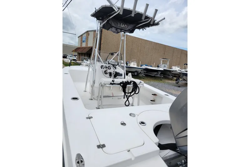 Slide: The Image of 2002 Rinalli 2100 boat with T-top and steering console, parked outdoors. - 5