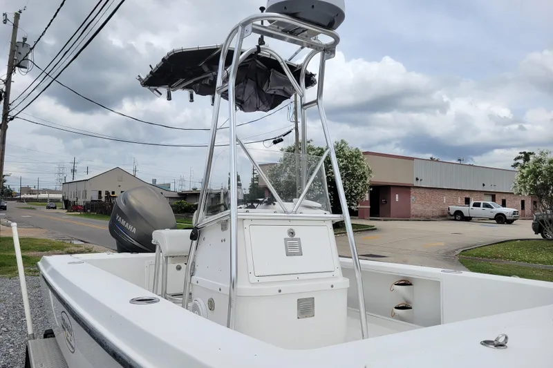 Slide: The Image of 2002 Rinalli 2100 boat with Yamaha engine, parked outdoors under cloudy sky. - 7