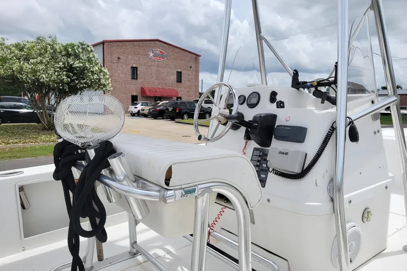 Slide: The Image of 2002 Rinalli 2100 boat interior with steering wheel and control panel, parked near a building. - 8