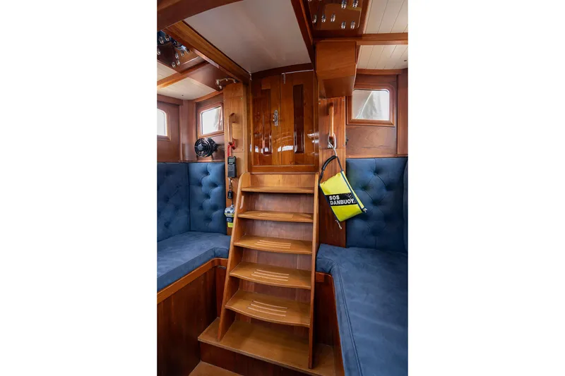 Slide: The Image of Interior of 2011 Spirit 50 DH yacht with wooden stairs and blue cushioned seating. - 12