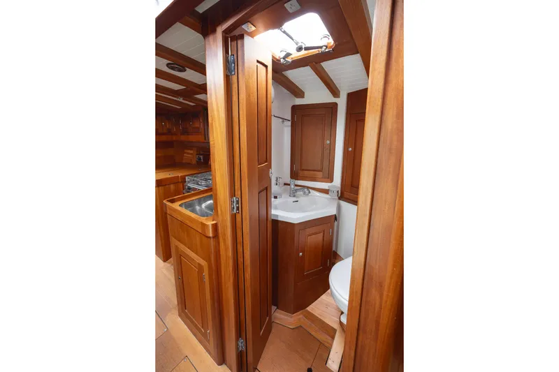 Slide: The Image of Interior of 2011 Spirit 50 DH yacht, featuring wooden cabinetry and compact bathroom. - 26