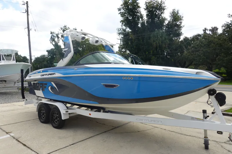 Slide: The Image of 2017 Centurion Ri217 boat in blue on trailer, parked outdoors. - 4