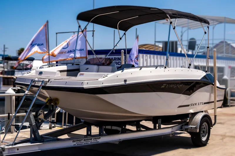 Slide: The Image of 2023 Starcraft SVX 171 OB boat on trailer, displayed outdoors with canopy and flags. - 5