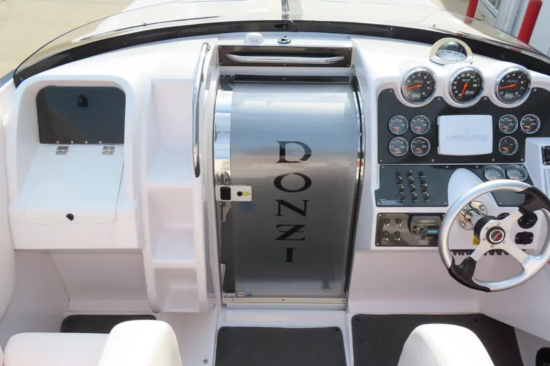 Slide: The Image of 2007 Donzi 35 ZR boat dashboard with gauges, steering wheel, and control panel. - 15