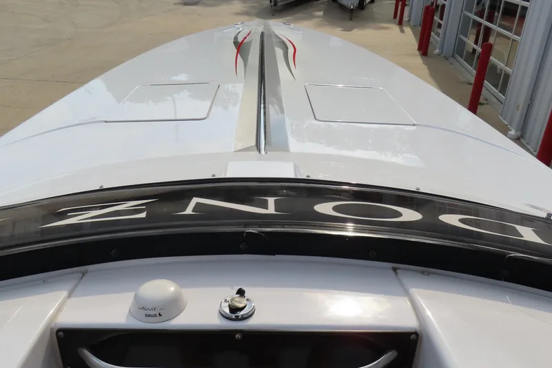 Slide: The Image of 2007 Donzi 35 ZR boat, sleek white design with red accents, docked outdoors. - 19