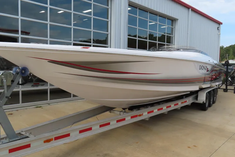 Slide: The Image of 2007 Donzi 35 ZR speedboat on trailer, parked outside a modern garage. - 4