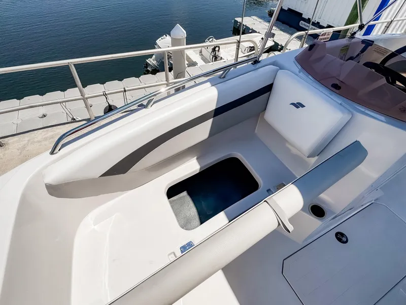 Slide: The Image of 2023 Starcraft SVX 171 OB boat interior with seating and storage, docked by the water. - 20