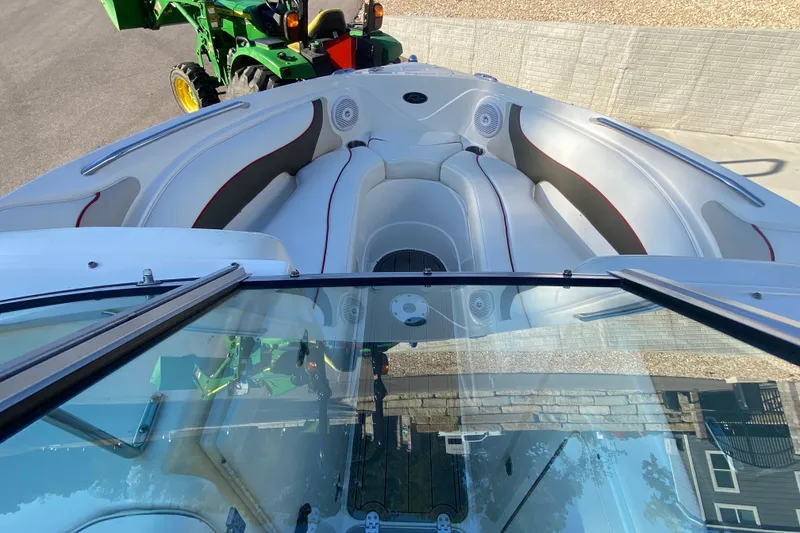 Slide: The Image of 2008 Rinker 246 Captiva Bowrider interior with seating, viewed from above, near a green tractor. - 12