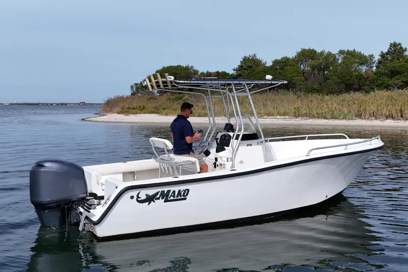 The Image of 2008 Mako 212 Center Console boat on calm water near a sandy shoreline. - 0