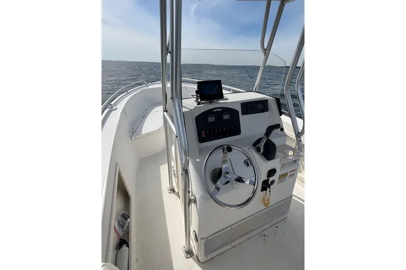 Slide: The Image of 2008 Mako 212 Center Console boat on open water, featuring steering wheel and control panel. - 13