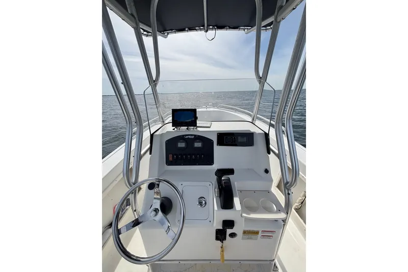 Slide: The Image of 2008 Mako 212 Center Console boat dashboard with steering wheel and ocean view. - 16