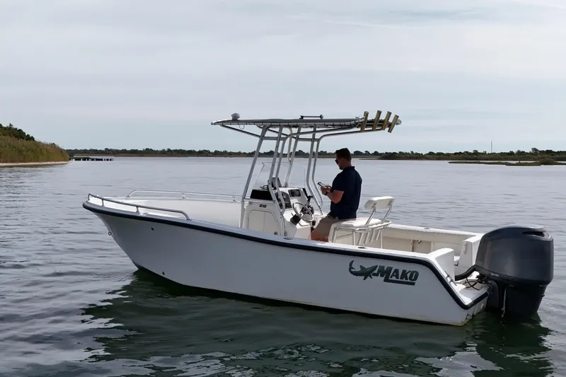 Slide: The Image of 2008 Mako 212 Center Console boat on calm water with a person onboard. - 4