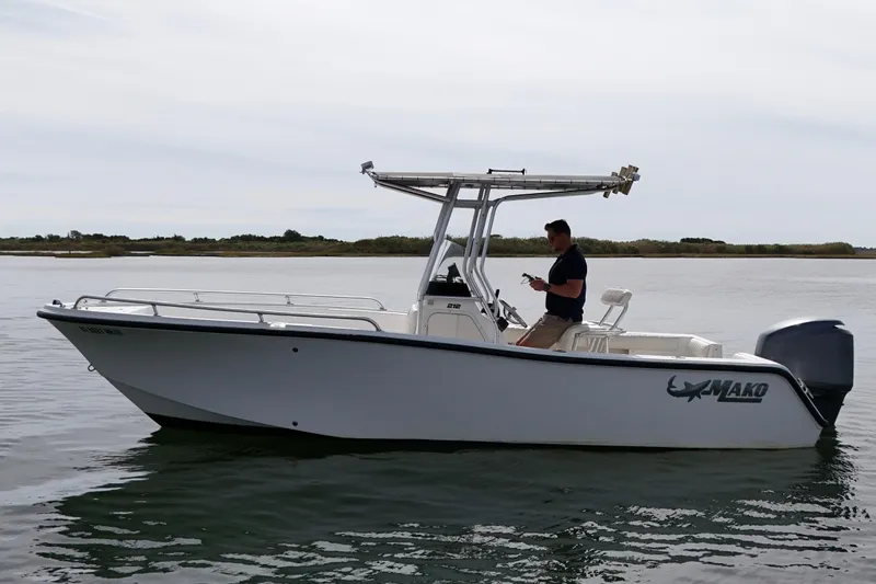 Slide: The Image of 2008 Mako 212 Center Console boat on calm water with a person onboard. - 5