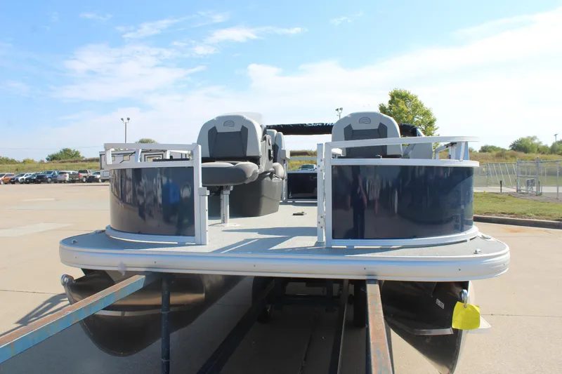 Slide: The Image of 2026 Sun Tracker Bass Buggy 16 XL Select pontoon boat on trailer, outdoor setting. - 2