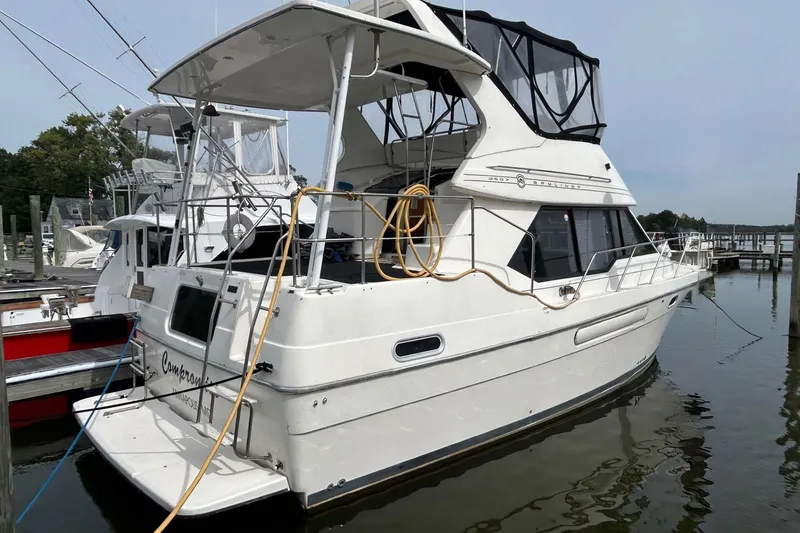 Slide: The Image of 1997 Bayliner 3587 Motoryacht docked at marina, featuring spacious upper deck. - 1