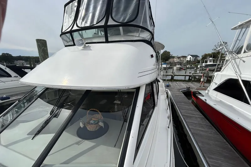 Slide: The Image of 1997 Bayliner 3587 Motoryacht docked at marina, featuring sleek design and spacious deck. - 11