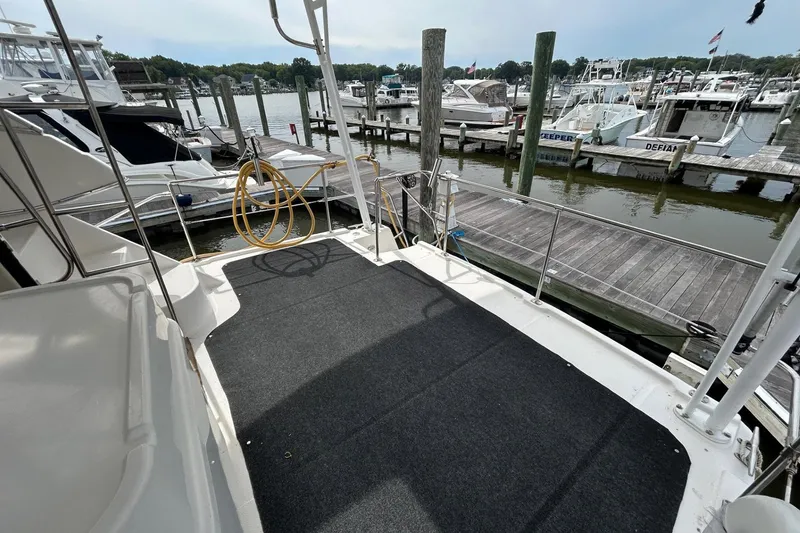 Slide: The Image of 1997 Bayliner 3587 Motoryacht docked at marina, featuring spacious deck area. - 12