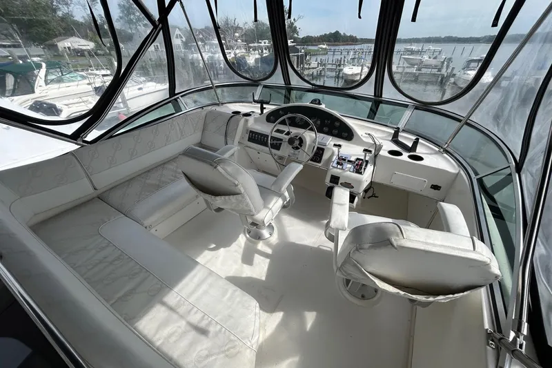 Slide: The Image of 1997 Bayliner 3587 Motoryacht helm with panoramic windows and white seating. - 14