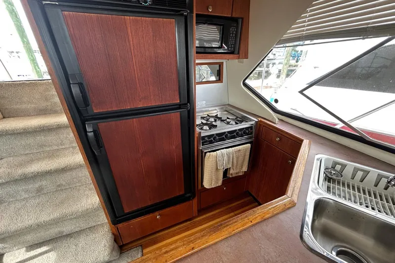 Slide: The Image of 1997 Bayliner 3587 Motoryacht kitchen with stove, microwave, and sink. - 22