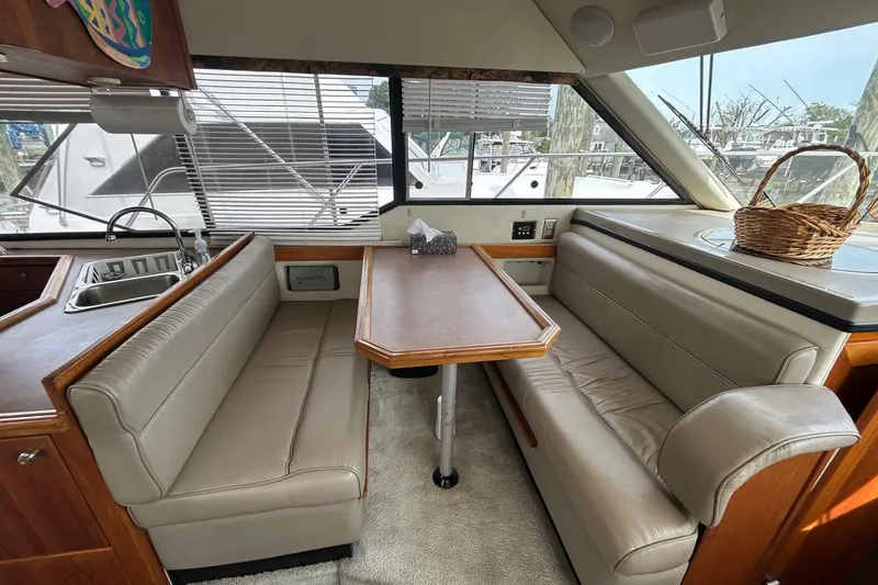 Slide: The Image of 1997 Bayliner 3587 Motoryacht interior with dining area, leather seating, and kitchen sink. - 23