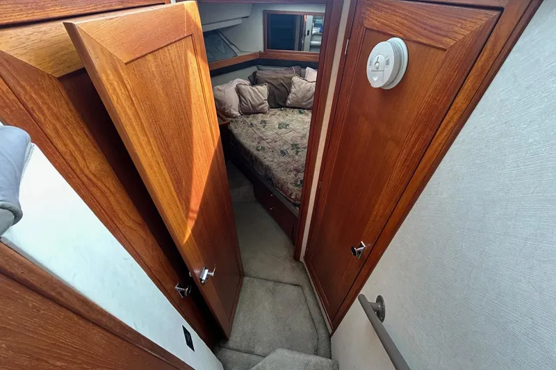 Slide: The Image of 1997 Bayliner 3587 Motoryacht interior with wooden doors and cozy bedroom. - 26