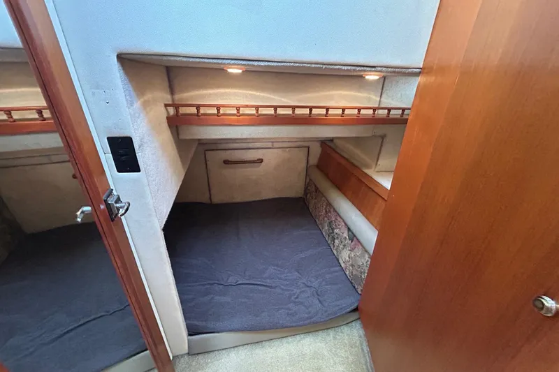 Slide: The Image of 1997 Bayliner 3587 Motoryacht cabin interior with cozy bed and wooden accents. - 29
