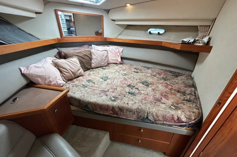 Slide: The Image of 1997 Bayliner 3587 Motoryacht bedroom with floral bedding and wooden accents. - 30