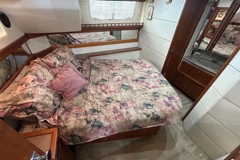 Slide: The Image of Cozy bedroom in 1997 Bayliner 3587 Motoryacht with floral bedding and ensuite sink. - 32