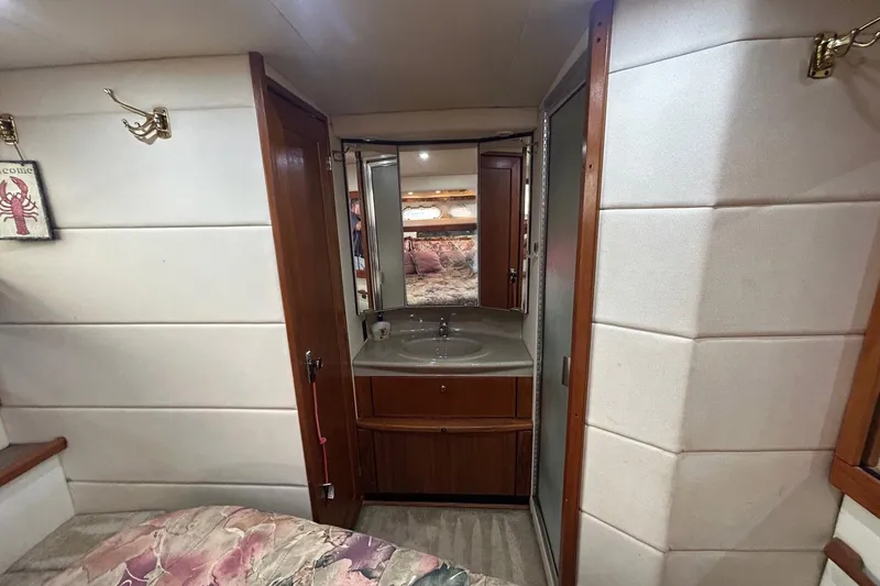 Slide: The Image of 1997 Bayliner 3587 Motoryacht interior with sink, mirror, and cozy cabin decor. - 33