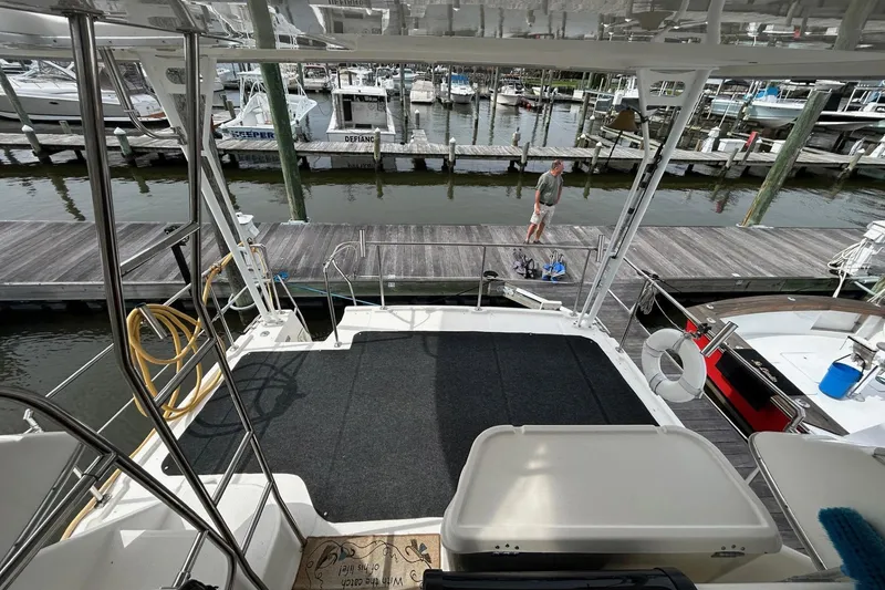 Slide: The Image of 1997 Bayliner 3587 Motoryacht docked at marina, view from deck, person on pier. - 6
