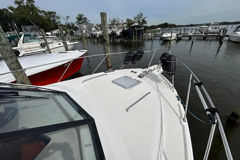 Slide: The Image of 1997 Bayliner 3587 Motoryacht docked at marina, surrounded by other boats. - 8