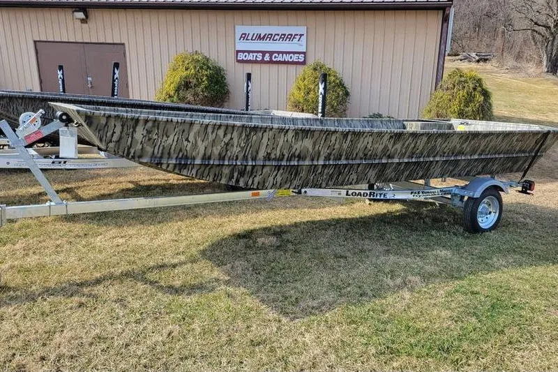 The Image of 2025 Smoker Craft 1648 jon boat on trailer, parked on grass near Alumacraft building. - 1