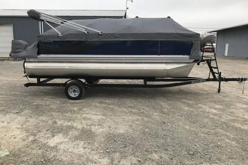Slide: The Image of 2026 Avalon 19 Venture Quad Fish pontoon boat on trailer, covered and parked outdoors. - 28
