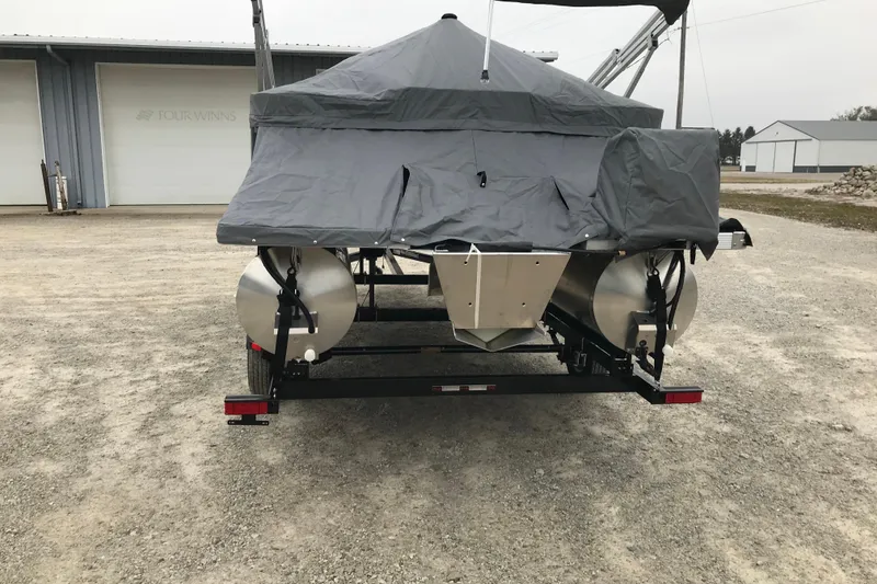 Slide: The Image of 2026 Avalon 19 Venture Quad Fish pontoon boat covered, parked on gravel. - 30