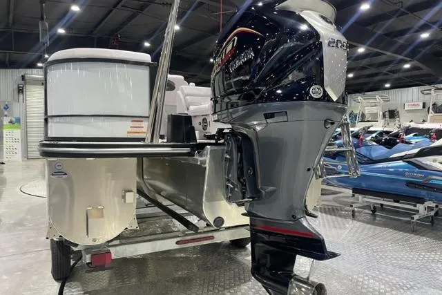 Slide: The Image of 2024 SunCatcher Select 322RC pontoon boat with powerful outboard motor in showroom. - 2