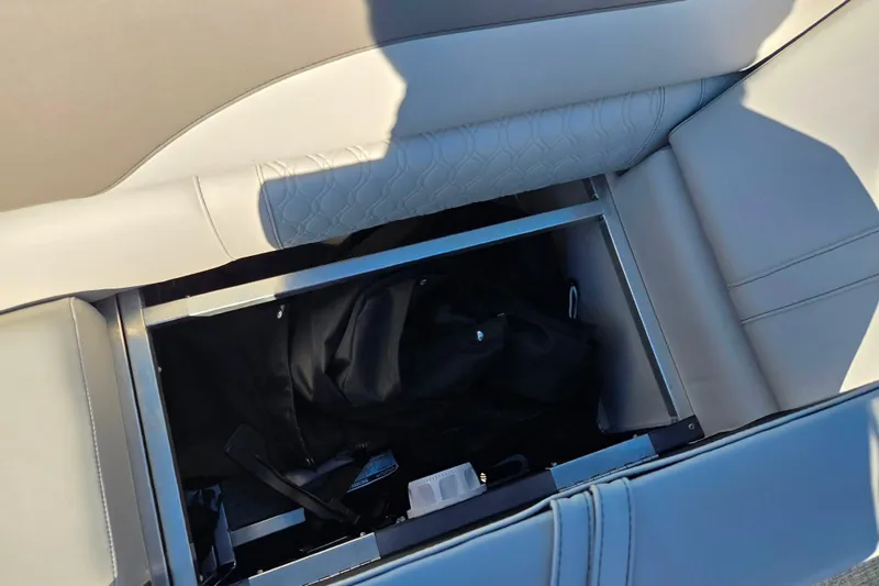 Slide: The Image of 2023 Avalon LSZ Quad Lounger storage compartment with open seat revealing interior space. - 17